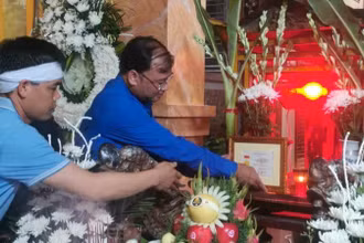 Bí thư Tỉnh đoàn Thái Bình Thiệu Minh Quỳnh đặt Huy hiệu "Tuổi trẻ dũng cảm" trước di ảnh Trung úy công an Đỗ Văn Tú. (Ảnh: Tỉnh đoàn Thái Bình cung cấp)