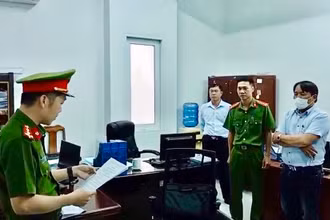 Trần Hữu Dũng (khoanh tay) nghe lệnh bắt bị can từ cơ quan chức năng.