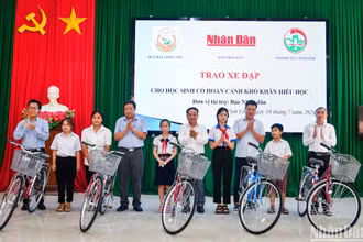 Đồng chí Đinh Như Hoan, Phó Tổng Biên tập Báo Nhân Dân trao tặng xe đạp cho học sinh có hoàn cảnh khó khăn hiếu học tại huyện Vĩnh Linh. (Ảnh: THÀNH ĐẠT)