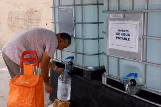 Một người dân lấy nước từ một bể chứa vì nước máy không thể uống được do hạn hán ở Teulada, Alicante, Tây Ban Nha (Ảnh: Reuters)