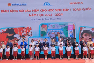 Đại diện Ủy ban An toàn giao thông Quốc gia, Bộ Giáo dục và Đào tạo, Công ty Honda Việt Nam trao tặng mũ bảo hiểm cho học sinh Trường tiểu học Phú Đô, Hà Nội, tháng 9/2023. (Ảnh: nhandan.vn)