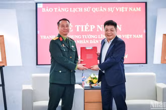 Đồng chí Quế Đình Nguyên, Phó Tổng Biên tập Báo Nhân Dân và Đại tá Lê Vũ Huy, Giám đốc Bảo tàng Lịch sử Quân sự Việt Nam trao biên bản tiếp nhận bộ tranh các vị tướng tài danh.