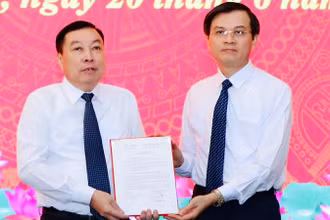 Đồng chí Đoàn Minh Huấn, Ủy viên Trung ương Đảng, Bí thư Tỉnh ủy Ninh Bình trao quyết định cho đồng chí Đinh Văn Tiên. (Ảnh: ĐỨC LAM)
