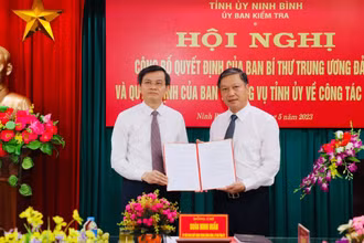 Đồng chí Đoàn Minh Huấn, Ủy viên Trung ương Đảng, Bí thư Tỉnh ủy Ninh Bình trao Quyết định của Ban Bí thư Trung ương Đảng cho đồng chí Đinh Việt Dũng. (Ảnh: ĐỨC LAM)