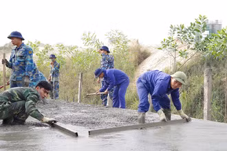 Cán bộ, chiến sĩ Lữ đoàn Công binh 131 (Quân chủng Hải quân) giúp nhân dân phường An Hồng, quận Hồng Bàng, thành phố Hải Phòng rải bê-tông mặt đê hữu sông Cấm.
