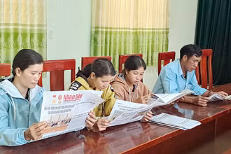 Đọc báo đầu ngày làm việc tại xã Rô Men, huyện Đam Rông, tỉnh Lâm Đồng. (Ảnh MAI VĂN BẢO) 