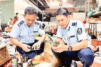 Lực lượng quản lý thị trường kiểm tra một kho hàng kinh doanh online các sản phẩm giả nhãn hiệu trên địa bàn TP Pleiku, tỉnh Gia Lai. (Ảnh QUYÊN LƯU)