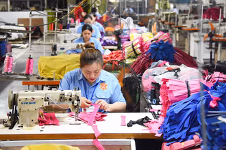 Công nhân Công ty LADODA may túi, cặp da. (Ảnh ĐỨC ANH)