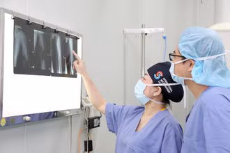 Các bác sĩ Bệnh viện Hữu nghị Việt Đức đánh giá hiệu quả điều trị cho người bệnh qua kết quả chụp X-quang. (Ảnh NGUYỄN ĐỨC)