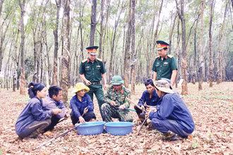 Anh Kpuih Sinh (hàng ngồi thứ tư từ trái sang), trao đổi kỹ thuật cạo mủ cao-su với công nhân.