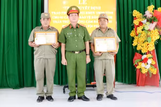 Đại tá Diệp Văn Thế, Phó Giám đốc Công an tỉnh Kiên Giang trao bằng khen của Ủy ban nhân dân tỉnh cho ông Cao Thế Nhiên và ông Phạm Hoài Ân.