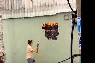 Lực lượng tham gia chữa cháy đập tường để tiến hành chữa cháy. 