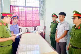 Điều tra viên tống đạt lệnh bắt tạm giam 4 tháng đối với Lê Minh Điệp (áo sơ mi sọc).