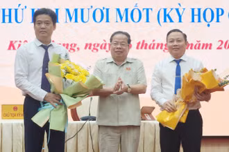 Chủ tịch Hội đồng nhân dân tỉnh Kiên Giang Mai Văn Huỳnh tặng hoa chúc mừng ông Lê Quốc Anh (bìa trái) và ông Lê Hữu Toàn (bìa phải).