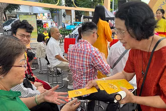 Tiến sĩ Quách Thu Nguyệt lì xì sách cho người dân tham dự chương trình.
