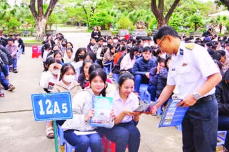 Báo cáo viên tuyên truyền, phát tờ rơi về thu hút nguồn nhân lực tại Trường THPT Hùng Vương, thành phố Quy Nhơn. (Ảnh THANH SANG)
