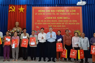 Bộ trưởng Tô Lâm tặng quà và chúc tết các hộ gia đình nghèo. (Ảnh: Báo Công an nhân dân)