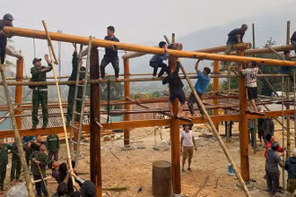 Các lực lượng trợ giúp hộ dân ở khu phố Tén Tằn xây lắp ngôi nhà sàn.