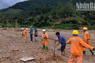 Công nhân Điện lực khu vực Mai Sơn-Yên Châu cùng nhân dân dựng cột tạm, kéo dây cấp điện trở lại cho người dân bản Nhụng Trên.