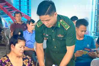 Cán bộ Đồn biên phòng Mường Lạn phát tờ gấp tuyên truyền pháp luật cho bà con dân tộc thiểu số tại xã biên giới Nậm Lạnh, huyện Sốp Cộp.