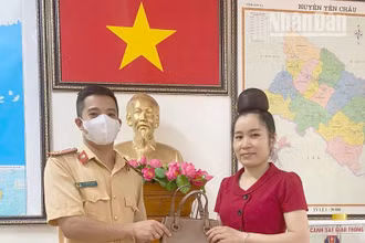 Thượng úy Lê Lâm Tùng trả lại chiếc túi xách cho chị Lường Thị Giang.