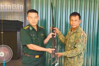 Cán bộ Đồn Biên phòng Mường Cai tiếp nhận 2 khẩu súng tự chế.