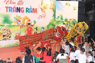 Các em thiếu nhi hào hứng thưởng thức tiết mục múa lân. (Ảnh: HẢI TIẾN)