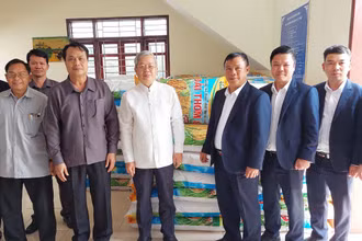 Đại diện lãnh đạo Công ty 705/Quân khu 2 bàn giao 10 tấn thóc giống cho chính quyền tỉnh Oudomxay (Lào). (Ảnh: Hải Tiến)