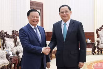 Bí thư Thành ủy Hà Nội Đinh Tiến Dũng (bên trái) và Thủ tướng Lào Sonexay Siphandone. (Ảnh: TRỊNH DŨNG)