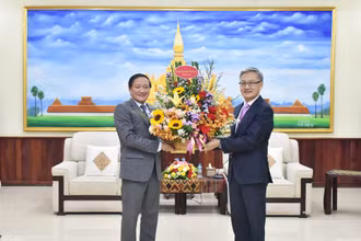 Đại sứ Nguyễn Bá Hùng chúc mừng Trưởng Ban Đối ngoại Trung ương Đảng Nhân dân Cách mạng Lào Thongsavanh Phomvihane. (Ảnh: Trịnh Dũng)