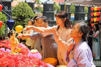 Chư tăng, phật tử cùng bà con kiều bào thực hiện nghi lễ tắm Phật. (Ảnh: Hải Tiến)