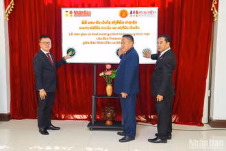 Đồng chí Lê Quốc Minh cùng lãnh đạo báo Pasaxon và lãnh đạo Ban Tuyên huấn Trung ương Đảng Nhân dân Cách mạng Lào nhấn nút khai trương báo Pasaxon điện tử mới. (Ảnh: TRỊNH DŨNG)