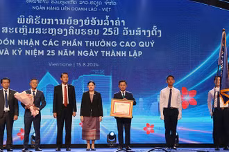Ngân hàng liên doanh Lào-Việt đón nhận Huân chương Lao động hạng Nhất của Lào. (Ảnh: Hải Tiến)