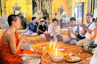 Người dân Lào tham gia nghi lễ buộc chỉ cổ tay đón năm mới 2567 theo Phật lịch của Lào. Ảnh: Trịnh Dũng