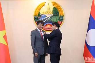 Phó Thủ tướng, Bộ trưởng Ngoại giao Lào thay mặt lãnh đạo Đảng, Nhà nước và Chính phủ Lào trao tặng Huân chương Itxala hạng Ba cho Đại sứ Việt Nam tại Lào Nguyễn Bá Hùng. (Ảnh: HẢI TIẾN)
