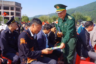Cán bộ Đồn Biên phòng cửa khẩu Chi Ma (Lộc Bình) phát tờ rơi cho bà con sinh sống tại khu vực cửa khẩu.