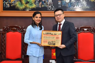 Tổng Biên tập Báo Nhân Dân Lê Quốc Minh nhận quà lưu niệm của Phó Tổng Biên tập Báo Granma Arlin Alberty Loforte. (Ảnh: THỦY NGUYÊN)