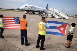 Nhân viên mặt đất cầm cờ Mỹ và Cuba đón chuyến bay thương mại đầu tiên giữa hai nước trong hơn 50 năm, tại Sân bay quốc tế Abel Santamaria của Cuba, ngày 31/8/2016. (Ảnh: Reuters)