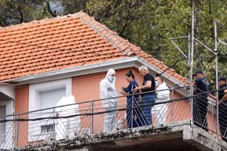 Công tố viên và nhân viên pháp y làm việc tại ngôi nhà xảy ra án mạng ở thành phố Cetinje. (Ảnh: Reuters)