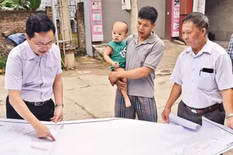 Cán bộ Trung tâm Phát triển quỹ đất huyện Mê Linh khảo sát thực địa công tác giải phóng mặt bằng đường vành đai 4 đoạn qua xóm Trại A, thôn Khuê Ngoại, xã Văn Khê. (Ảnh: DUY LINH)