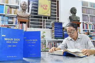 Nhà báo Mai Sông Bé với các số báo Nhân Dân hằng tháng mà ông đã dày công sưu tầm và đóng thành quyển để lưu giữ.