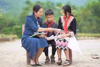 Cô giáo Lê Na hướng dẫn bài tập Ngữ văn cho học sinh là con em đồng bào dân tộc thiểu số tại sân Trường Phổ thông dân tộc nội trú trung học cơ sở Kỳ Sơn (huyện Kỳ Sơn, tỉnh Nghệ An).