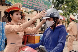 Lực lượng Cảnh sát giao thông Công an tỉnh Đắk Nông trao mũ bảo hiểm tặng người dân trên đường về quê đón Tết.