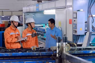 Cán bộ Tổng công ty Điện lực thành phố Hà Nội hướng dẫn doanh nghiệp sử dụng điện tiết kiệm.