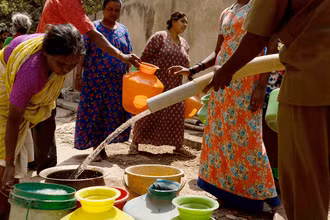 Người dân thành phố Bengaluru, miền nam Ấn Ðộ xếp hàng lấy nước. (Ảnh REUTERS)