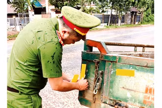 Công an thị xã Buôn Hồ dán decal cho xe công nông của người dân.