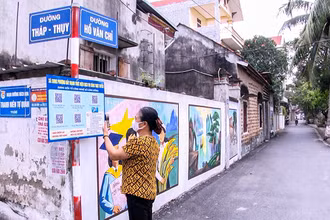 Người dân xã Song Phượng (huyện Ðan Phượng) quét mã QR tìm hiểu thủ tục hành chính. (Ảnh THẮNG VĂN)