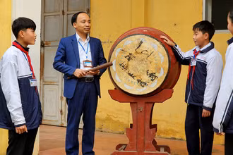 Thầy giáo Nguyễn Văn Ngọc trao đổi với học sinh về mô hình “Tiếng trống học bài”.