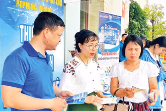 Cán bộ Bảo hiểm xã hội Hải Phòng tuyên truyền chính sách bảo hiểm xã hội tự nguyện, bảo hiểm y tế hộ gia đình tại các phiên giao dịch việc làm. (Ảnh QUANG MINH)