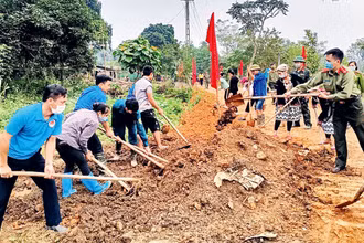 Cán bộ các cơ quan tỉnh Tuyên Quang tham gia san gạt, đắp lề đường cùng nhân dân thôn Mỏ Nghiều 2, xã Tân Thành, huyện Hàm Yên.